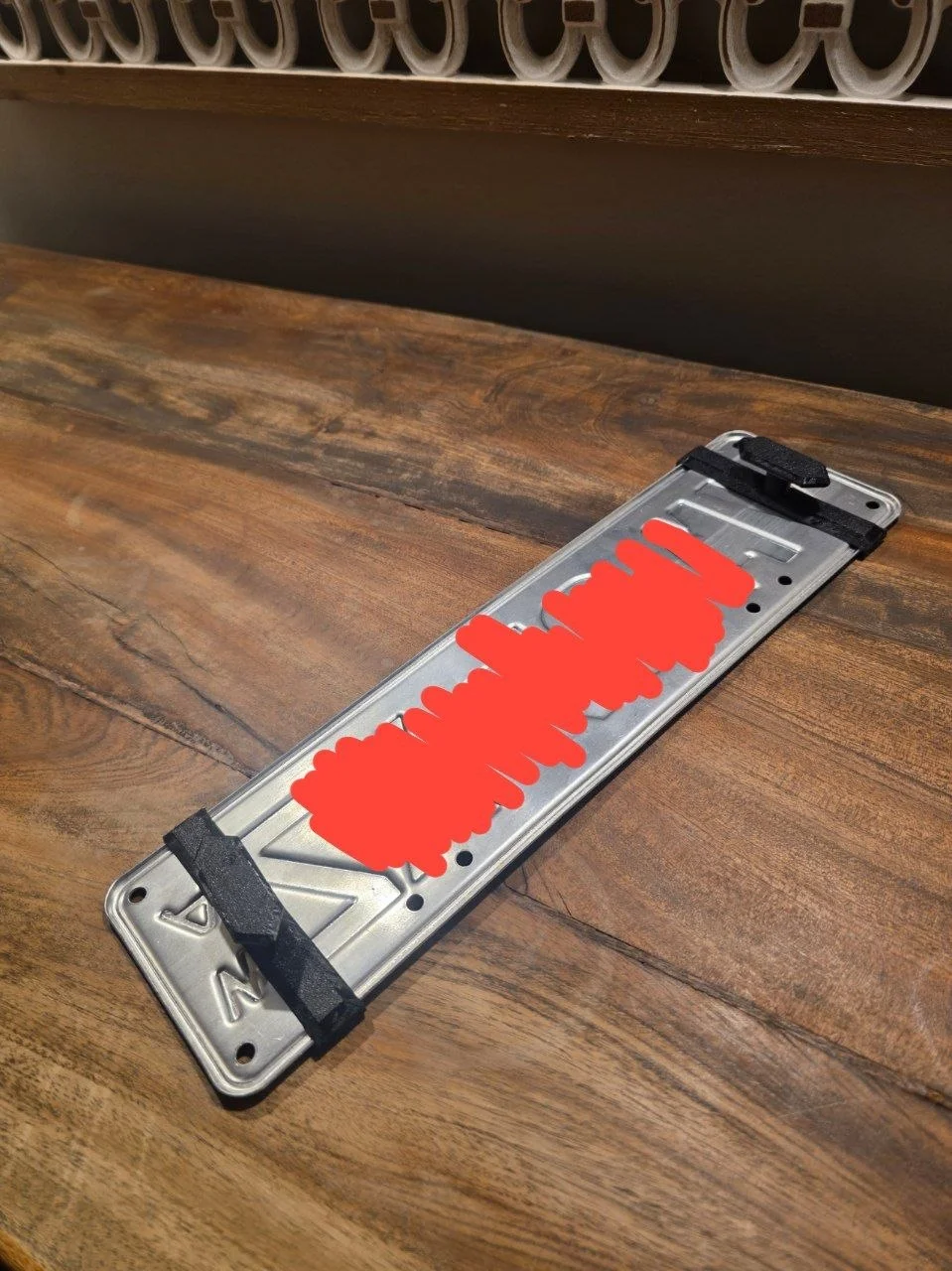 Front bracket holding the plate — bracket clips through mesh, screw locks from inside